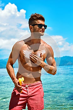 Summer Skincare. Man Applying Sunscreen Protection Body Lotion