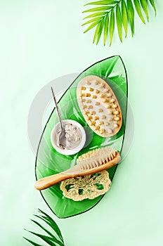 Summer spa setting background with cosmetic clay and massage brushes