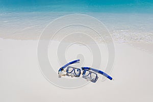 Summer sport, beach activity beach recreational banner. Diving goggles snorkel gear on white sand near sea waves