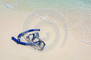 Summer sport, beach activity beach recreational banner. Diving goggles snorkel gear on white sand near sea waves