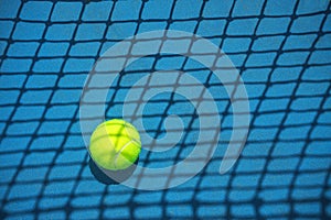 Summer sport concept with tennis ball and net on hard tennis court