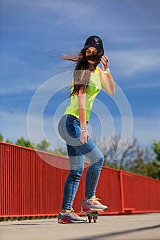 Summer sport. Cool girl skater riding skateboard