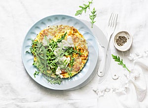 Summer squash frittata with goat cheese and arugula - delicious healthy diet food on a light background