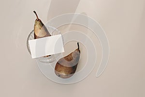 Summer still life composition. Modern business card mock up scene. Two pears fruit, glass with long harsh shadows