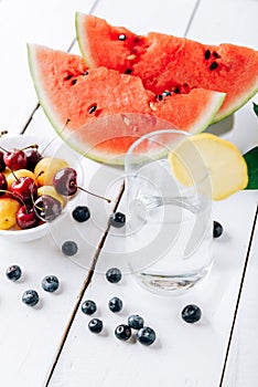 Summer still life of fresh fruit and berries on a white wooden surface