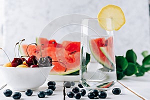 Summer still life of fresh fruit and berries on a white wooden surface