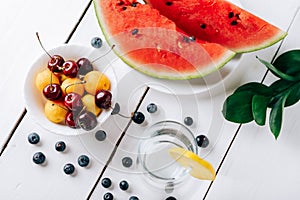 Summer still life of fresh fruit and berries on a white wooden surface