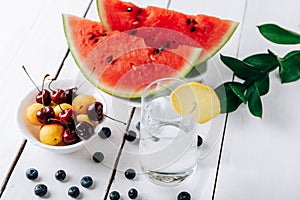 Summer still life of fresh fruit and berries on a white wooden surface