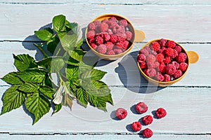 Summer still life, fresh raspberries in a mug on a blue wooden background, rustic style