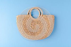 Summer straw bag on blue background.