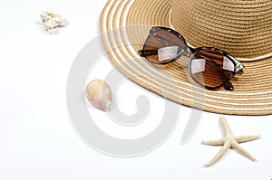 Summer straw hat, sunglasses, shells, starfish on white background