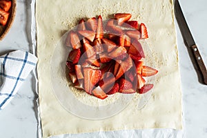 Summer strawberry galette with almond flakes in making. Food preparation concept