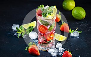 Summer strawberry mojito cocktail with lime, white rum, soda, cane sugar, mint, and ice in glass on deep blue background. Cold