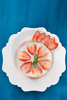 Summer strawberry mousse cake with fresh berries on the wooden blue background top view