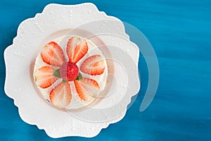 Summer strawberry mousse cake with fresh berries on the wooden blue background top view