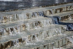 Summer street fountain. Water flows down the stairs.