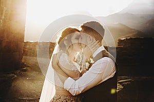 Summer sun shines over stunning wedding couple walking in lonely Georgian town