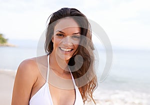 Summer sun smiles. Cropped portrait of a beautiful young woman on the beach.