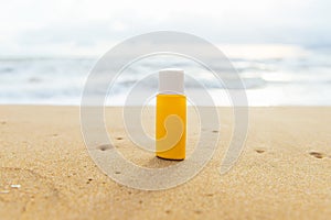 Summer sunbath. Sun lotion bottle in the sand