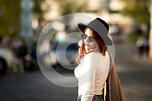 Summer sunny lifestyle fashion portrait of young stylish hipster woman walking on the street.