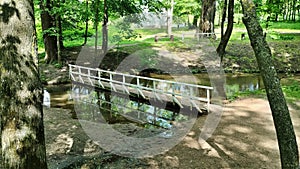 Summer sunny park landscape with bridge over the river in Belarus.