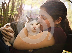 Summer sunny photo of teenager girl hugging cat