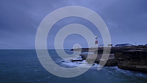 Summer sunrise with stormy clouds and slow shutter speed at Portland Bill Light, Dorset, UK