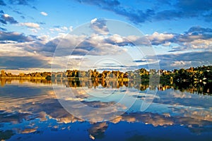 Summer sunset evining sky and clouds reflection in water