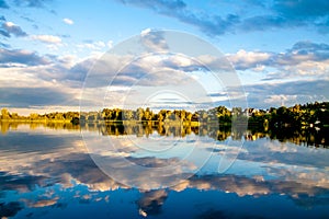 Summer sunset evining sky and clouds reflection in water
