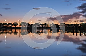 Summer sunset on the lake with clouds reflection