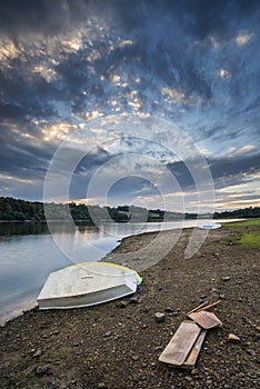 Summer sunset over lake in landscape with leisure boats and equi