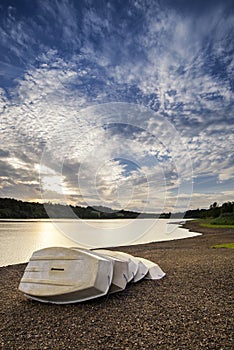 Summer sunset over lake in landscape with leisure boats and equi