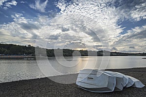 Summer sunset over lake in landscape with leisure boats and equi