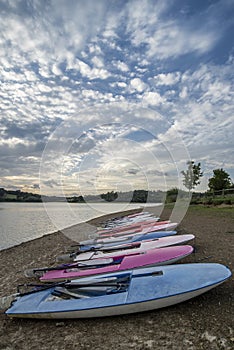 Summer sunset over lake in landscape with leisure boats and equi