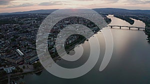 Summer Sunset over Mainz approaching the Dom with the Rhine river with cargo ships and reflections on the water and old bridge in