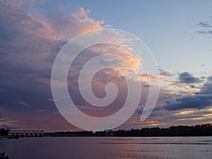 Summer sunset on the river and exterior lighting of the hydroelectric dam