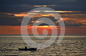 Summer sunset at sea with fishermen boat