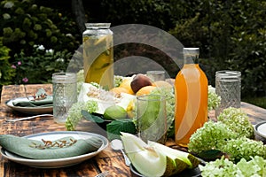 Summer table set. Outdoor dining. Table decorated fresh flowers and fruits.