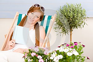 Summer terrace red hair woman relax in deckchair