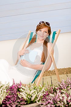 Summer terrace red hair woman relax in deckchair