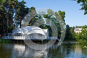 Summer terrace restaurant white tent on the pier on the pond