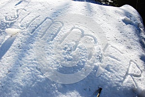 Summer text written on snow for texture or background - winter holiday concept. Sunny day, top view, clean and nobody
