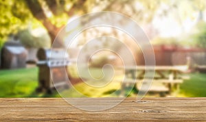 summer time in backyard garden with grill BBQ, wooden table, blurred background