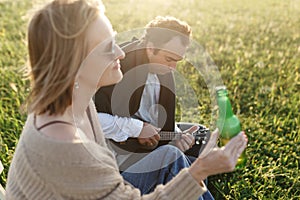 Summer time. Beautiful young couple enjoying time in field around grass. Lifestyle, love, dating, vacation concept