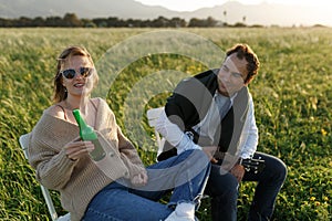 Summer time. Beautiful young couple enjoying time in field around grass. Lifestyle, love, dating, vacation concept