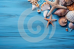 Summer time concept with sea shells and starfish on a blue wooden background and sand with copy space