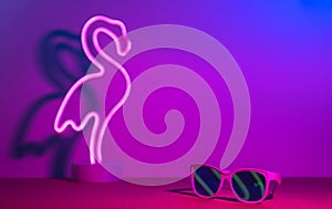 Summer time with flamingo,sunglasses refection neon pink and blue and green light on table with copy space.Trendy vacation holiday