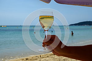 Summer time in Provence, glass of cold white wine on Pampelonne sandy beach near Saint-Tropez in Var department, France