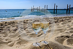 Summer time in Provence, two glasses of cold champagne cremant sparkling wine on famous Pampelonne sandy beach near Saint-Tropez