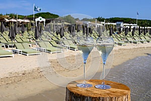 Summer time in Provence, two glasses of cold champagne cremant sparkling wine on famous Pampelonne sandy beach near Saint-Tropez